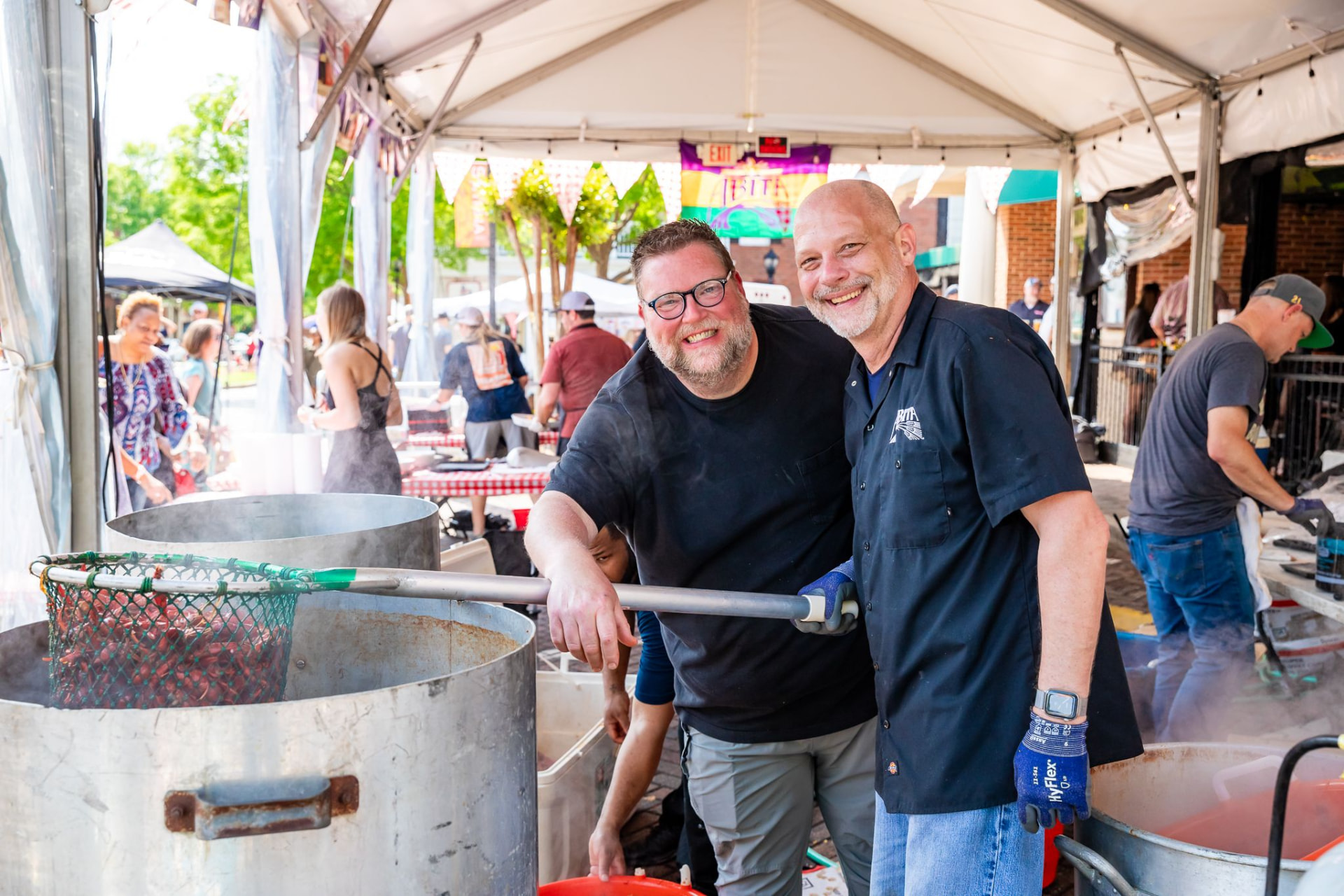 Crawfish being pulled from boiling pots under the festival tent